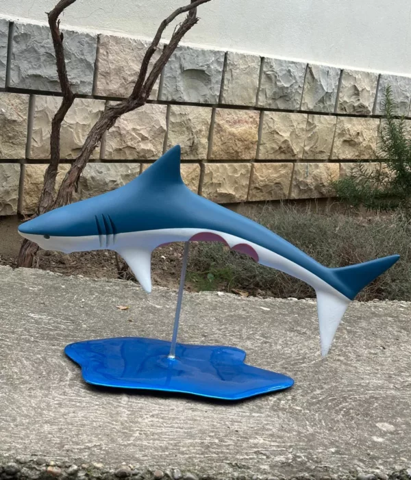 Sculpture d'un requin bleu et blanc mordu au ventre de Julien Gudéa